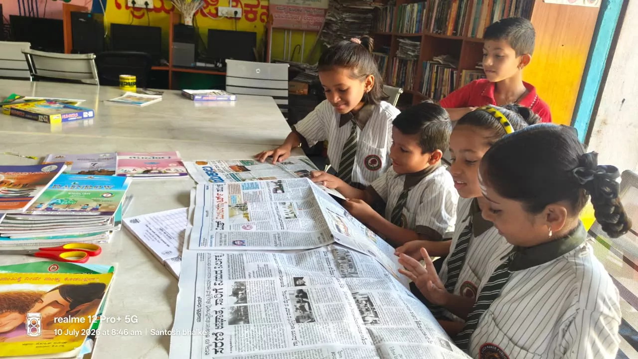 Schoolchildren reading newspapers together at a gram panchayat library